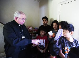Archbishop Gomez hands out gifts to one of the Adopt-a-Family recipients in 2019. (Victor Alemán)
