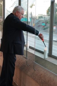 Archbishop José H. Gomez lights a candle in support of medical workers and their families along the edge of the Cathedral of Our Lady of the Angels plaza overlooking the 101 freeway in downtown Los Angeles. (Sarah Yaklic)