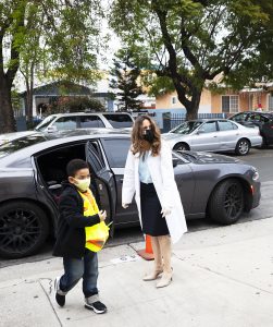 Resurrection School principal Carolina Saenz welcomes a student during morning drop-offs on Feb. 1, the first day of Catholic Schools Week. (Victor Alemán)