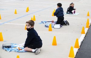 Kindergarteners at Holy Name of Mary School in San Dimas have a snack in their numbered areas on the school’s basketball court. (Victor Alemán)