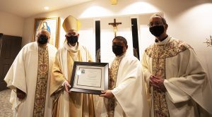 Archbishop Gomez, left, and Fr. Garcia, right, display the plaque designating the new Queen of Angels Center for Priestly Formation with Assistant Vicar for Clergy Fr. Jim Anguiano, far left, and Bishop Trudeau, far right. (Victor Alemán)