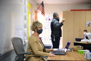 A third grade teacher listens to Principal De Loera on the first day back to the classroom. (David Amador Rivera)