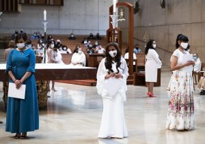 The wives stand on the altar during the ordination Mass. (Victor Alemán)
