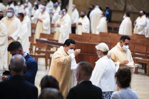 Father Sergio Hidalgo distributes communion. (Victor Alemán)