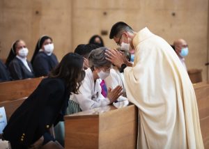 Father Francis Kim gives a first blessing to his family. (Victor Alemán)