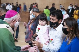 Archbishop Gomez blesses a couple and their child at the World Marriage Day Mass Feb. 13. (Victor Alemán)