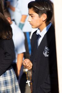 A student prays the rosary at St. Joseph School in La Puente. 