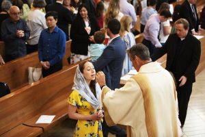One of the new deacons distributes Holy Communion at the ordination Mass. (Victor Alemán)