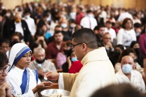 New priest Father Daniel Lopez distributes communion. (Victor Alemán)