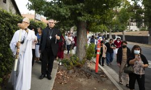 Faithful participated in a candlelight procession and vigil to welcome the relic of St. Bernadette on July 31. At left are Deacon Carper and Bishop Jean-Marc Micas of Tarbes-Lourdes, France. (Victor Alemán) 