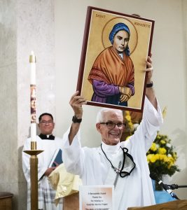 Deacon Jim Carper holds an image of St. Bernadette at the Mass to welcome her relics to Los Angeles. (Victor Alemán)