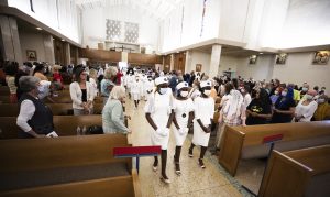 Members of the Ladies Auxiliary Division of the Knights of Peter Claver process into St. Bernadette Church in Baldwin Hills during the welcome Mass for the relics on Monday, Aug. 1. (Victor Alemán) 