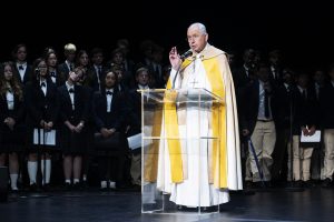 Archbishop José H. Gomez speaks while the student choir from St. Monica Academy High School in Montrose, which performed at the event, looks on. (Victor Alemán)