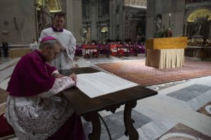 Archbishop Georg Gänswein, private secretary to Pope Benedict, signs a scroll known as a 