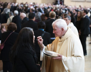Msgr. Jarlath “Jay” Cunnane offers Communion during Bishop David O'Connell's funeral Mass. (Victor Alemán)
