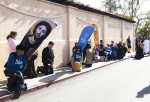 Parishioners along the procession route kneel as the Blessed Sacrament passes by during the 6-mile eucharistic procession that went from Mission San Gabriel Arcángel to St. Luke the Evangelist Church in Temple City, then back to the mission. (Victor Alemán)