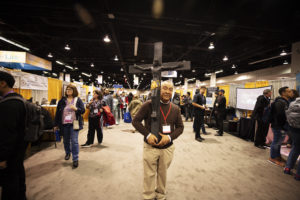 Deacon Paulino Juarez of the archdiocesan Office of Life, Justice and Peace carries a crucifix in the exhibit hall of the Anaheim Convention Center during the Los Angeles Religious Education Congress Feb. 26. 