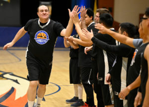 A member of Team Priests gives out high fives during the Feb. 17, 2023, vocations matchup. (John McCoy)