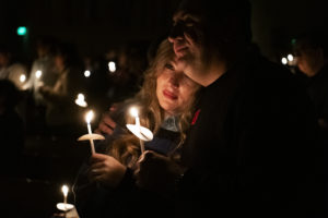 A couple basks in the glow of the flame from the Paschal Candle spread via smaller candles during the Easter Vigil Mass at Cathedral of Our Lady of the Angels on April 8. (Victor Alemán)
