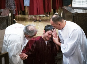 One of the nine adult catechumens welcomed into the Catholic Church at the cathedral this Easter emerges from the baptismal pool during the Easter Vigil. (Victor Alemán)