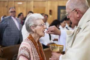 Msgr. John Moretta, pastor of Resurrection Church in Boyle Heights, offers communion during a special Mass on April 30 celebrating 55 years since his ordination to the priesthood and 40 years at Resurrection. (Victor Alemán)