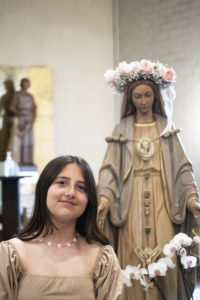 Krista Baaklini, a seventh-grader at St. Dorothy School in Glendora, poses with the crowned Blessed Virgin Mary during a May 5 May Crowning Mass. (Victor Alemán)
