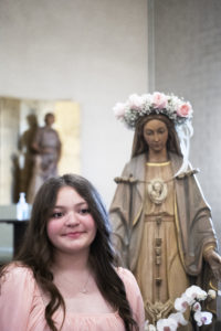 Lola Oceguera, a seventh-grader at St. Dorothy School in Glendora, poses with the crowned Blessed Virgin Mary during a May 5 May Crowning Mass. (Victor Alemán)