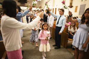 Mila Guiterrez, center, a first-grader at St. Dorothy School in Glendora, walks under a flower arch during a May 5 May Crowning Mass. (Victor Alemán)