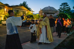 Transitional deacon Alejandro Reynaga carries the Blessed Sacrament during the Carmelite Sisters of the Most Sacred Heart of Los Angeles' special Mass and candlelight procession in response to the Dodgers' decision to honor the Sisters of Perpetual Indulgence on Friday, June 16. (John Rueda/ADLA)