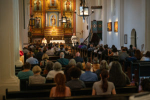 Attendees sit in the restored church the reopened Mission San Gabriel Arcángel. (John Rueda/ADLA)