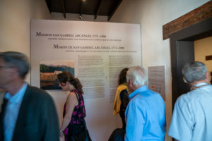 Attendees check out the new exhibit highlighting the history of the reopened Mission San Gabriel Arcángel. (John Rueda/ADLA)