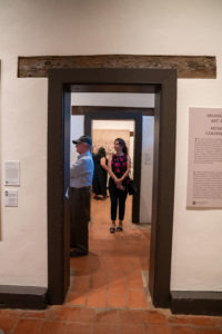 Attendees check out the new exhibit highlighting the history of the reopened Mission San Gabriel Arcángel. (John Rueda/ADLA)