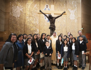 Students, parents and others pose with Msgr. Terrance Fleming during the annual Missionary Childhood Association Youth Mass on Oct. 17 at Cathedral of Our Lady of the Angels. (Victor Alemán)