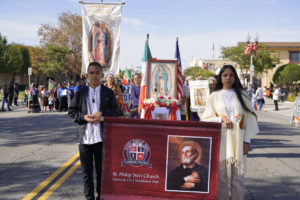 Parishioners from St. Philip Neri Church walk with their sign during the 92nd Procession and Mass honoring Our Lady of Guadalupe and St. Juan Diego on Dec. 3. (Sarah Yaklic)