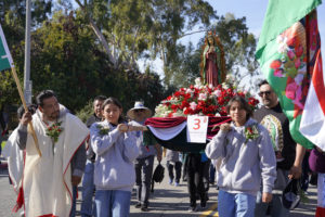 Participants walk with decorated floats during the 92nd Procession and Mass honoring Our Lady of Guadalupe and St. Juan Diego at East LA College Stadium on Dec. 3. (Sarah Yaklic)