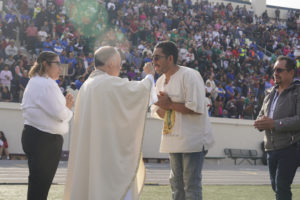 Los Angeles Auxiliary Bishop Brian Nunes offers holy Communion to those attending the 92nd Procession and Mass honoring Our Lady of Guadalupe and St. Juan Diego at East LA College Stadium on Dec. 3. (Sarah Yaklic)