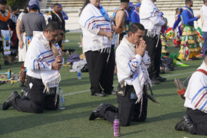 Participants kneel while waiting to receive holy Communion during the 92nd Procession and Mass honoring Our Lady of Guadalupe and St. Juan Diego at East LA College Stadium on Dec. 3. (Sarah Yaklic)