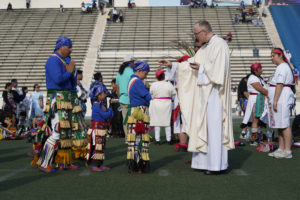 Los Angeles Auxiliary Bishop Slawomir Szkredka offers holy Communion to those attending the 92nd Procession and Mass honoring Our Lady of Guadalupe and St. Juan Diego at East LA College Stadium. (Sarah Yaklic)