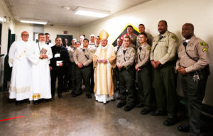 Los Angeles Archbishop José H. Gomez poses with sheriff deputies and others at Men’s Central Jail in Los Angeles where he celebrated Christmas Mass the morning of Dec. 25.  (Victor Alemán)