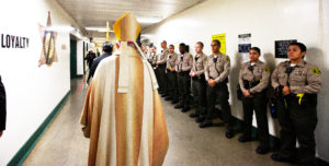 Los Angeles Archbishop José H. Gomez processes past sheriff deputies at Men’s Central Jail in Los Angeles where he celebrated Christmas Mass the morning of Dec. 25.  (Victor Alemán)