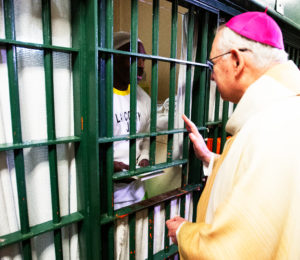 Los Angeles Archbishop José H. Gomez handed out copies of “The Twelve Steps and the Sacraments” by Scott Weeman to inmates at Men’s Central Jail in Los Angeles after celebrating Christmas Mass the morning of Dec. 25.  (Victor Alemán)