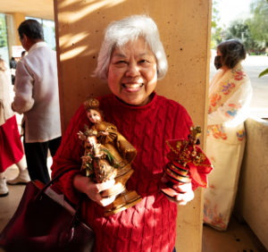 A parishioner holds up her statue outside of the Cathedral of Our Lady of the Angels on Jan. 21 before the Feast of Santo Niño Mass. (Victor Alemán)