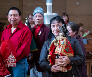 Parishioners at the Feast of Santo Niño Mass hold up their statue to be blessed during the event at the Cathedral of Our Lady of the Angels on Jan. 21. (Victor Alemán)