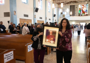 Attendees at the memorial Mass carry a portrait of Auxiliary Bishop David O'Connell during the Feb. 24 event at Mission San Gabriel to mark the one-year anniversary of his death. (Victor Alemán)