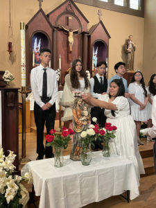 Leah Cacao, an eighth-grader at Holy Trinity School in Atwater Village, crowns the Mary statue with her classmates during a May Crowning event on May 1. (Karen Lloyd)