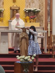 Student Victoria Kaspar crowns Mary during a May Crowning event at Saints Felicitas and Perpetua Church in San Marino.  (Noreen Maricich)