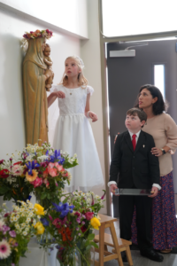 Hadley Reta and Nathan Adams help crown the Mary statue while teacher Tina Mortillaro looks on during a May Crowning event on May 5 at St. Julie Billiart Church in Newbury Park. (Pam List)