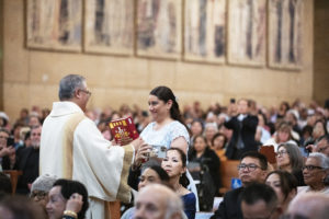 Cynthia Sosa, right, smiles after her husband, Renee, received the Book of Gospels during the ordination Mass. (Victor Alemán)