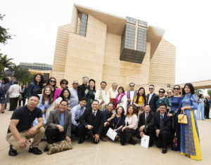 Hieu Tran and his wife, Thu, pose with friends and loved ones following his ordination Mass on June 8. (Victor Alemán)