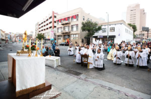 More than 300 priests, seminarians, and lay Catholics kneel in front of the Blessed Sacrament during a Eucharistic Procession through downtown LA’s Skid Row on Saturday, July 27. (Victor Alemán)